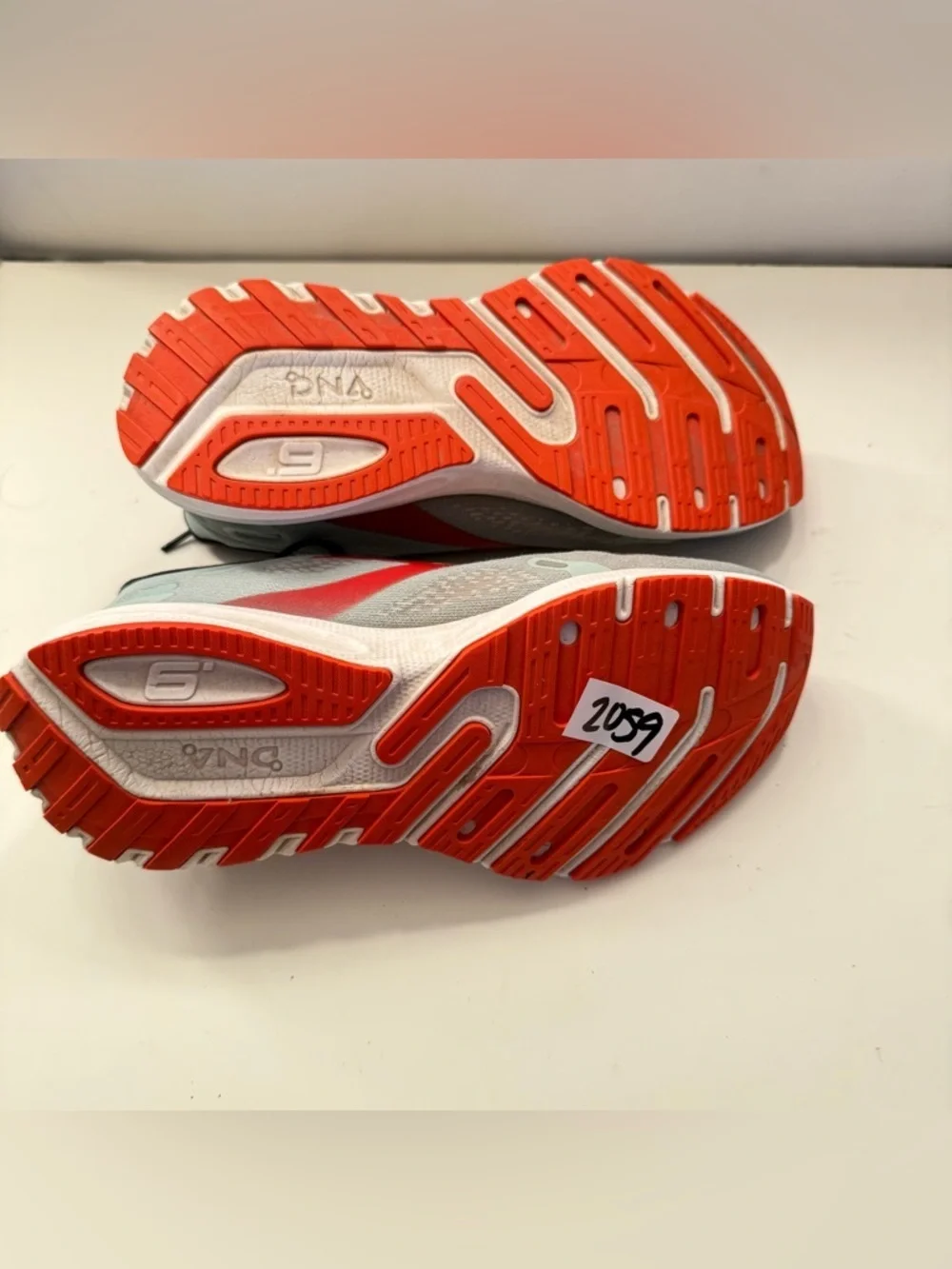 Brooks Light Gray Running Shoes with Red and Orange Accents